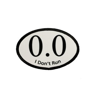 May include: White oval patch with black trim. The patch has the number "0.0" printed in black and the text "I Don't Run" printed below the number.