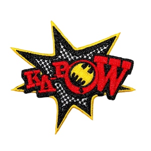 May include: A black and yellow starburst with a red and yellow "KAPOW" graphic with a black bat symbol in the center.