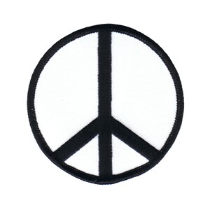 Könnte beinhalten: Ein weißer Peace-Zeichen-Patch mit schwarzem Umriss. Der Patch ist rund und hat einen Durchmesser von etwa 7,6 cm.