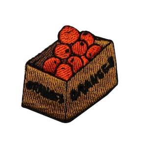 May include: A brown cardboard box filled with orange oranges. The box is labelled "ORANGES" on two sides.