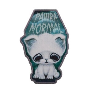 Könnte beinhalten: Ein weißes Kätzchen mit großen blauen Augen ist auf einem blauen und grünen Hintergrund abgebildet. Der Text "PAURA NORMAL" ist in gotischer Schrift über dem Kätzchen geschrieben.