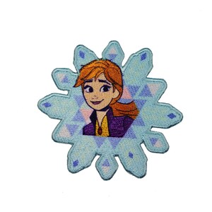 May include: An embroidered patch featuring a cartoon image of a girl with red hair and a purple jacket. The girl is surrounded by a blue snowflake design.