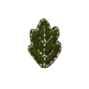 May include: A green felt leaf with gold stitching. The leaf is a simple design with a single vein running down the center.