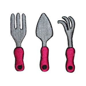 May include: Three embroidered iron-on patches of kitchen utensils: a fork, a knife, and a spoon. The utensils are silver with pink handles.