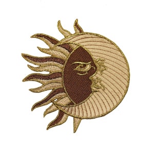 May include: Embroidered patch featuring a sun and moon design. The sun is depicted as a stylized face with a golden outline and brown rays. The moon is a crescent shape with a brown outline and a beige interior.