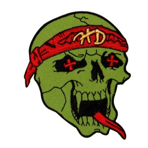 May include: Green skull with a red bandana and cross-shaped eyes. The bandana has the letters "HD" embroidered on it.
