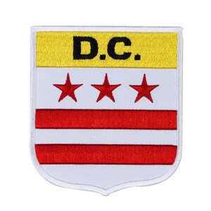 May include: Embroidered patch featuring the D.C. flag design. The patch has a yellow top section with the letters "D.C." in black. Below are three red stars and a red stripe on a white background. The patch has a white border.