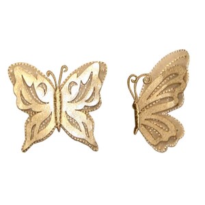 May include: Two gold-colored butterfly embellishments with intricate cut-out designs. The butterflies are made of a fabric-like material and have a delicate, feminine aesthetic.