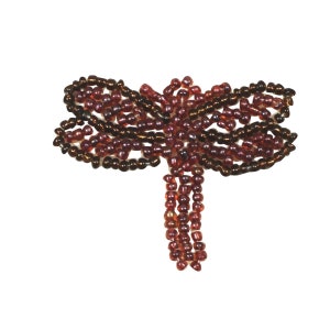 May include: A beaded dragonfly with a brown and burgundy color scheme. The dragonfly is made of small, round beads that are sewn together to create the shape of the insect. The dragonfly has two sets of wings and a long, thin body.