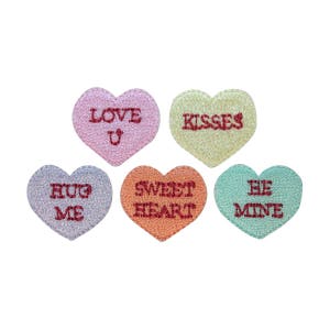 May include: Five heart-shaped candy conversation hearts with different messages: "Love U", "Kisses", "Hug Me", "Sweet Heart", and "Be Mine".