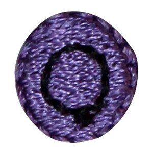 May include: Purple fabric button with a black embroidered letter Q.