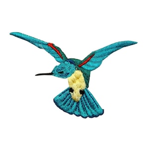 May include: A turquoise blue hummingbird with red and yellow accents, embroidered on a white background. The hummingbird is in flight with its wings spread out.