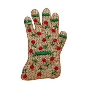 May include: A beige embroidered patch in the shape of a hand with red flowers and green leaves.