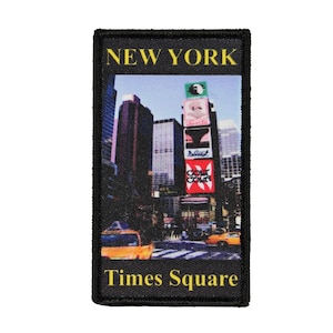 May include: A black and yellow embroidered patch with a photo of Times Square in New York City. The text "NEW YORK" is at the top of the patch and "Times Square" is at the bottom.