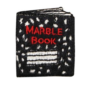 May include: A black and white embroidered patch with the words "MARBLE BOOK" in red thread. The patch has a white and black striped design.