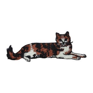 May include: An embroidered patch of a calico cat lying down with brown, black, and white fur.