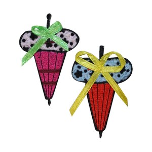 May include: Two embroidered iron-on patches shaped like ice cream cones with polka dots and bows. One patch is pink with a green bow and the other is blue with a yellow bow.