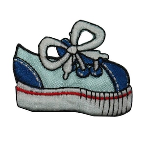 May include: A light blue and blue embroidered iron-on patch of a sneaker with white laces tied in a bow.