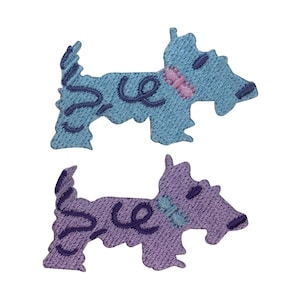 May include: Two dog-shaped fabric appliques. One is light blue with dark blue swirls and a pink collar. The other is purple with dark purple swirls and a blue collar. Both have a textured appearance and are set against a white background.