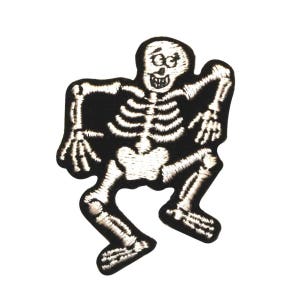 May include: A black and white embroidered patch of a skeleton dancing. The skeleton is smiling with a toothy grin and has a white outline.