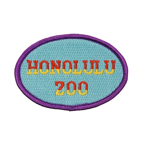 May include: An oval-shaped embroidered patch with a purple border. The patch is light blue with the text "HONOLULU ZOO" in yellow and red lettering.