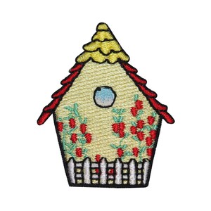May include: A yellow birdhouse with a red roof and a white picket fence. The birdhouse has a small window and is decorated with red berries and green leaves.