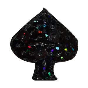 May include: A black fabric spade shape covered in iridescent sequins. The sequins are black with a rainbow sheen.