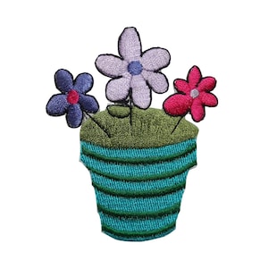 May include: A blue and green striped flower pot with three flowers. The flowers are purple, pink, and blue.