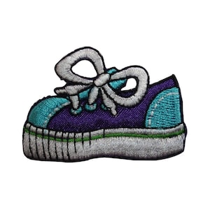 May include: Purple and teal embroidered iron-on patch of a cartoon sneaker with a white bow.