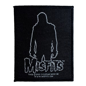 Könnte beinhalten: Schwarz-weiß gestickter Patch mit einer Silhouette eines Monsters und dem Text "MISFITS" in einer stilisierten Schriftart. Der Text "TM & © 2002 CYCLOPIAN MUSIC INC. WWW.MISFITS.COM" ist ebenfalls enthalten.