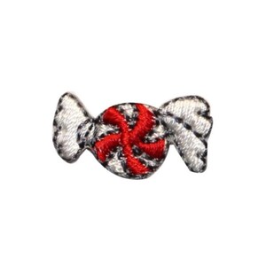 May include: A white candy with a red peppermint swirl design. The candy is wrapped in a white paper with a red stripe.