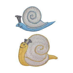 Peut inclure: Deux patchs de broderie en forme d'escargots, l'un bleu et l'autre jaune. Les escargots sont tournés dans des directions différentes et ont une coquille blanche avec un tourbillon brun.