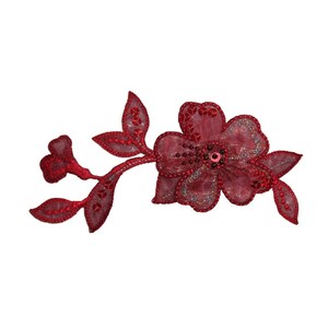 May include: A red embroidered flower applique with a beaded centre. The flower is on a branch with leaves.