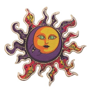 May include: A colorful embroidered patch featuring a sun with a crescent moon face. The sun has a yellow face with green eyes and a purple background. The sun's rays are red, orange, and yellow.