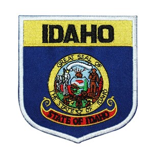Può includere: Una toppa ricamata blu e gialla con il sigillo dello stato dell'Idaho e il testo "IDAHO" e "STATE OF IDAHO".