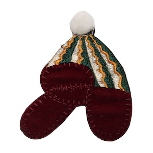 Könnte beinhalten: Ein roter Filz-Weihnachtsstrumpf mit einer grün-weiß-gold gestreiften Mütze und einem weißen Bommel oben.