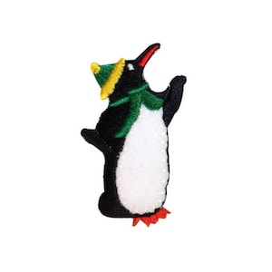 May include: An embroidered iron-on patch of a penguin wearing a green scarf and a yellow and green hat. The penguin is standing upright with its wings raised.