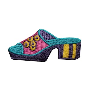 May include: A purple, pink, and teal embroidered patch of a high-heeled shoe with a gold design.