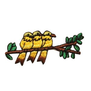 May include: Three yellow birds with brown accents are perched on a brown branch with green leaves. The birds are facing to the left and have their wings folded.