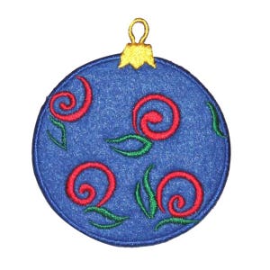 May include: A blue felt Christmas bauble with a gold top and red and green swirl designs.