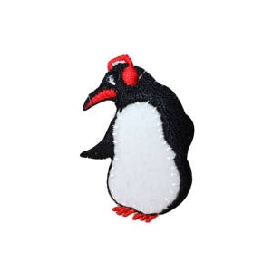 May include: A black and white penguin with a red beak and red feet. The penguin is wearing a red hat.