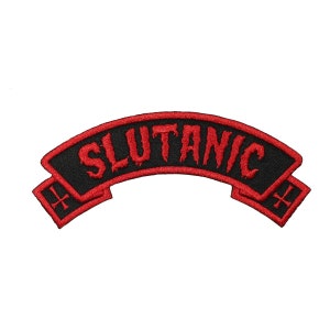 Könnte beinhalten: Schwarzer und roter gestickter Patch mit dem Text "SLUTANIC" in einer tropfenden Schriftart. Der Patch hat zwei rote Kreuze an den Enden.