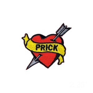 May include: A red heart with a yellow banner that says "PRICK" and is pierced by a gray arrow. The heart is a traditional tattoo style.