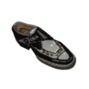 May include: Black and white embroidered iron-on patch of a dress shoe. The shoe has a white upper with black stitching and a black sole.