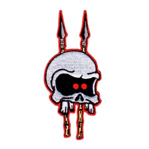 May include: White skull with red eyes and a black outline, pierced by two spears with brown shafts and gold tips. The skull is embroidered on a red background.