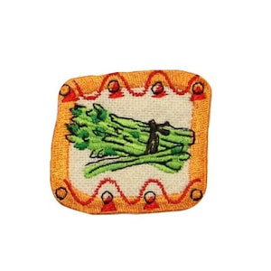 May include: An embroidered iron-on patch with a bunch of green asparagus in a yellow frame with red and orange accents.