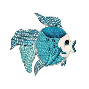 Può includere: Un toppa di pesce ricamata in blu e bianco con un viso bianco e un occhio nero. Il pesce ha un corpo blu con macchie bianche e una bocca bianca.