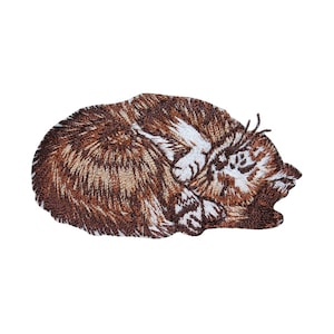 May include: Embroidered patch of a brown and white cat curled up sleeping. The cat is facing to the right and has its eyes closed.