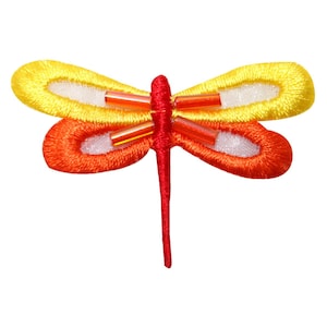 Può includere: Una libellula ricamata in rosso e giallo con un centro bianco e dettagli perlati.