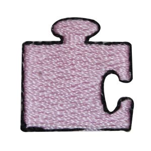 May include: A pink puzzle piece with a black outline. The piece is made of fabric and has a textured surface.